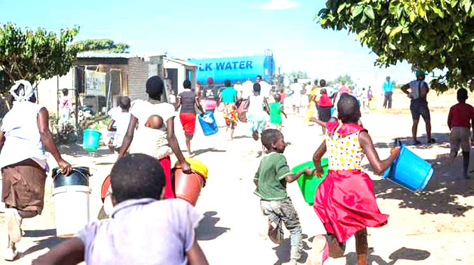 Budiriro residents race towards a bulk water tanker to get free water provided by Sammy Bennet Foundation. — Picture: Godwin Muzari
