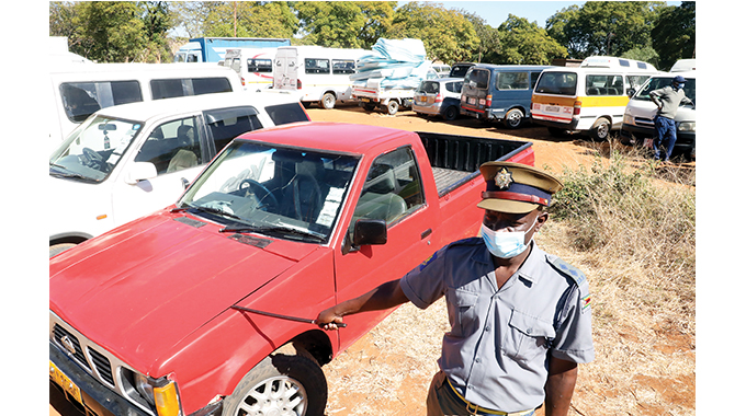 Bulawayo Police spokesperson Inspector Abednico Ncube yesterday shows some of the impounded vehicles at Ross Camp. (Picture Eliah Saushoma)