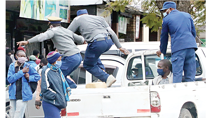 Police officers leap into action to round up some vendors who were still operating after the 3PM Covid-19 regulations to close shop in the Bulawayo city centre