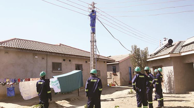 A Zesa Holdings employee disconnects electricity cables that were illegally connected in Stoneridge suburb, Harare South yesterday. — picture: Believe Nyakudjara