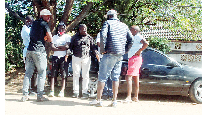 Hired bouncers outside the gate of the house under dispute