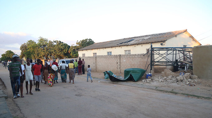 Mourners and passersby walk past the scene of the water tank tragedy which claimed two lives in Chitungwiza on Wednesday