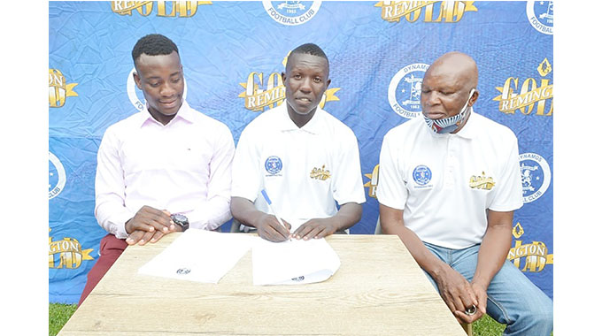 Tinashe Makanda signs what appears to be a Dynamos contract