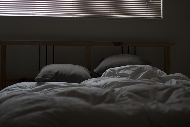 File picture of an unmade bed in the dark