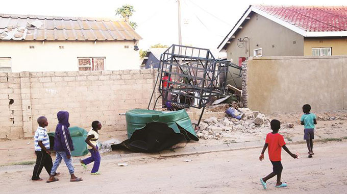 Children walk past the water tank which fell and killed nine-year-old Trinity Saungweme, together with Colleen Kamonere (18 months) and left the former’s brother Thulani (two years) with a broken leg in Chitungwiza on Wednesday. — Picture: Believe Nyakudjara