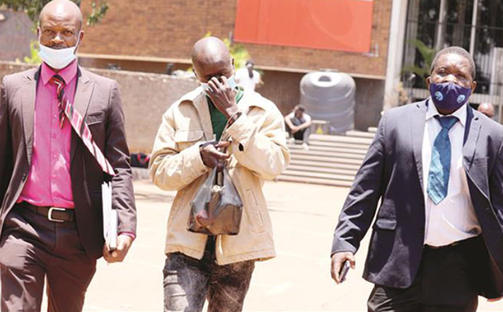 Detectives escort Gift Chemhuru as he appears at the Harare Magistrates Courts in connection with the kidnapping of a 4-week-old baby at Spar Montague recently. — Picture: Lee Maidza