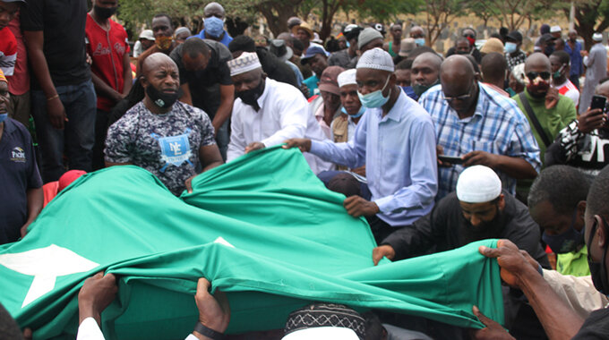 Body of the late socialite and fitness trainer Mitchell (Moana) Amuli being lowered into the grave the Moslem way, where the green cloth shields the body as it is received by those in the grave during burial at Warren Hills cemetery in Harare yesterday. — Picture: Innocent Makawa