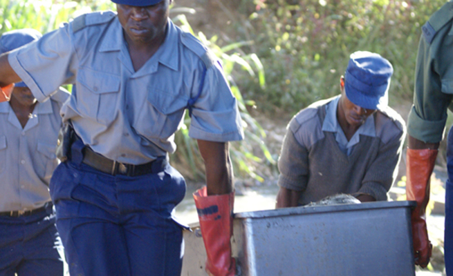 FILE picture of police carrying a body in a metal coffin