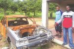 Gruesome killing shocks community Henry Mapxashike(in red jacket) and his cousin Brine Chitiga show the vehicle that was torched by Clever at his father’s homestead in Matova Village under Chief Zimuto