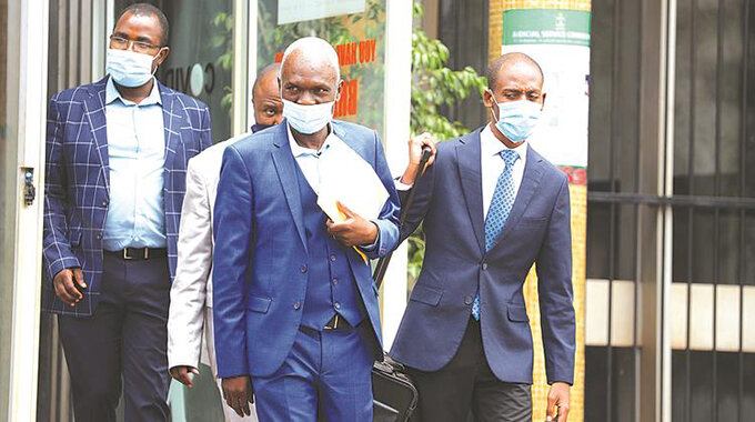 Zifa president Felton Kamambo (centre) appears at the Harare Magistrates Court yesterday. — Picture: Lee Maidza