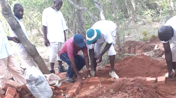 Members of Gringo’s Apostolic church work on his grave last Saturday in preparation of his memorial service