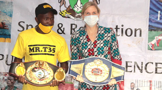 HAIL THE CHAMPION . . . Newly-crowned World Boxing Organisation Africa welterweight champion, Brendon “Boika” Denes (left), presents his belts to the Minister of Youth, Sport, Arts and Recreation, Kirsty Coventry, at a Press conference in Harare