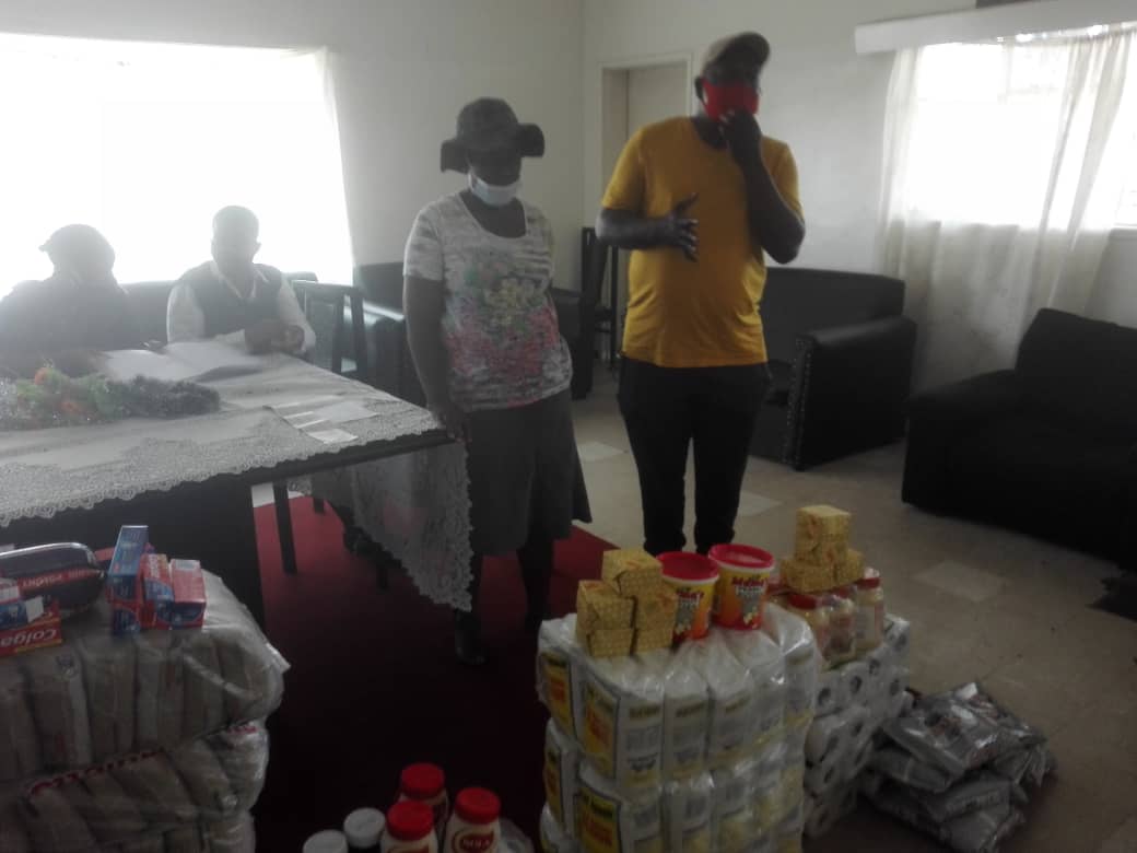 Ezra Sibanda (in yellow t-shirt) presenting the donation