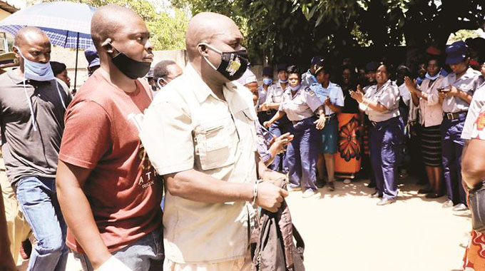 Sergeant Tichaona Chirinhe (handcuffed) is escorted by police detectives after making indications at his house in Chitungwiza