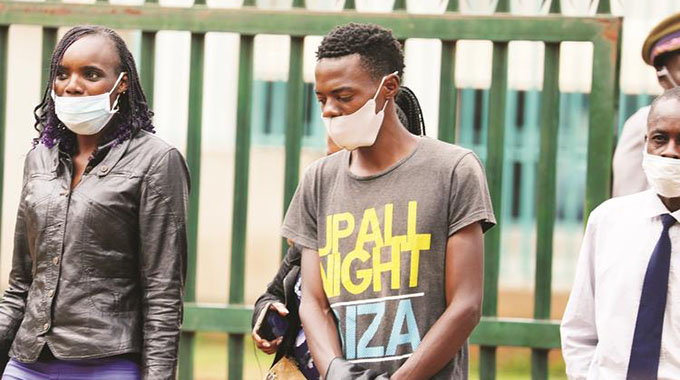 The pair that was arrested for producing fake Covid-19 test certificates being led into the Harare Magistrates Courts by police detectives yesterday - Picture: Lee Maidza