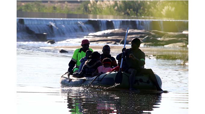Illegal border jumpers cross Limpopo river from Zimbabwe to South Africa using an inflated boat.