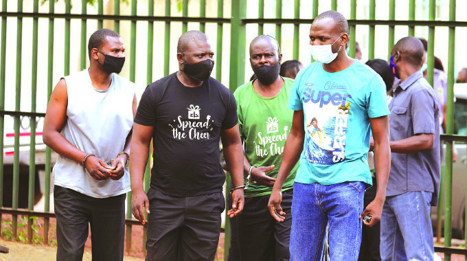Detectives escort the US$2,7 million Harare-Chirundu road robbery suspects into Harare Magistrates’ Court for their initial hearing yesterday. — Picture: Lee Maidza.