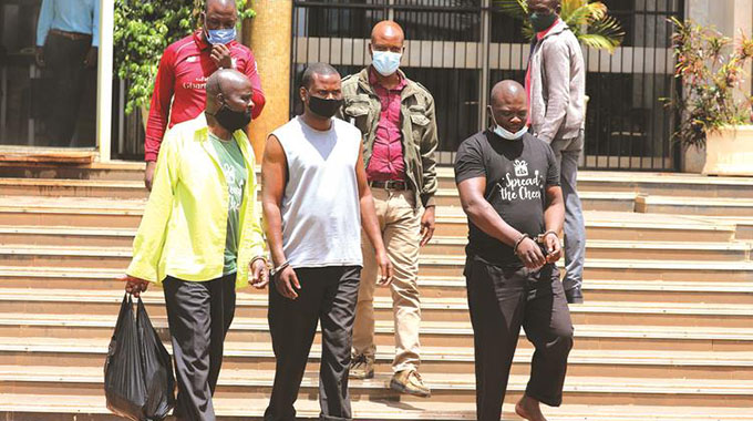 Police detectives escort the US$2.7million Harare-Chirundu Road robbery suspects into the Harare Magistrates Courts. — Picture: Lee Maidza