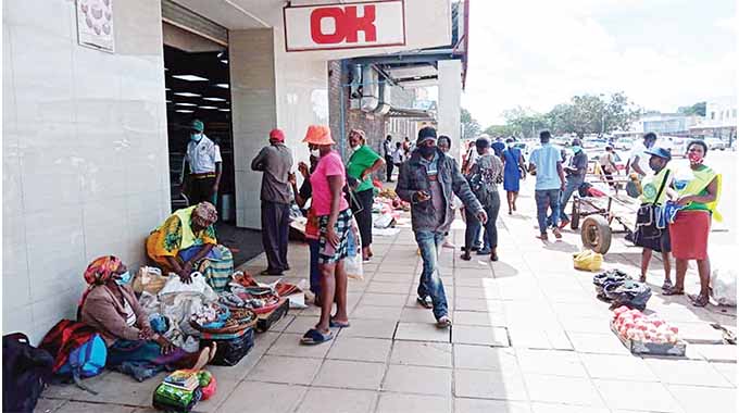 Vendors and money changers waiting for clients outside OK Supermarket in Gweru yesterday
