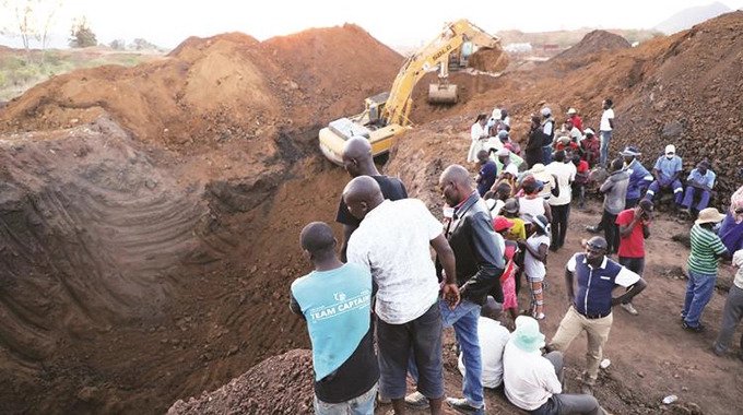 This file picture shows villagers watching as a Zimgold Fields excavator works on retrieving illegal gold miners that are suspected to have been buried alive in a mine shaft at Premier Estate in Mutasa, Manicaland, . — Picture: Tinai Nyadzayo