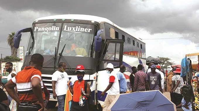 A Pangolin bus bound for South Africa picks up passengers at Mbudzi Roundabout along Harare-Masvingo Road yesterday despite a Government ban on intercity and long-distance bus services to curtail the spread of Covid-19. — Picture: Justin Mutenda