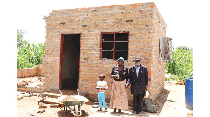 Mr Lewis Phiri and his wife Mrs Esnath Phiri in front of the almost complete room of their house under construction