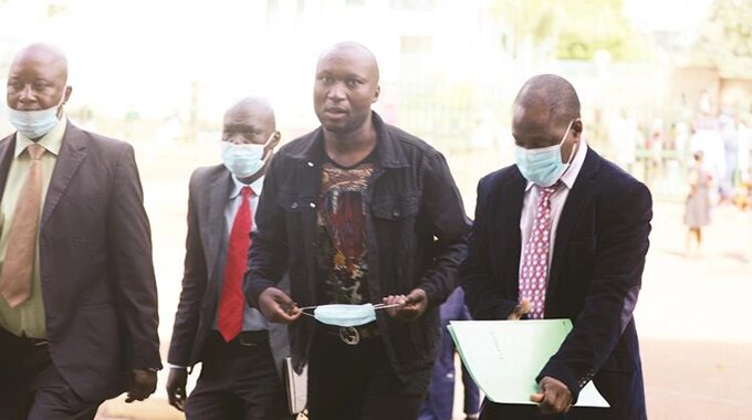Fraud suspect Moses January Banda (centre) arrives at the Harare Magistrates Court yesterday. — Picture: Lee Maidza