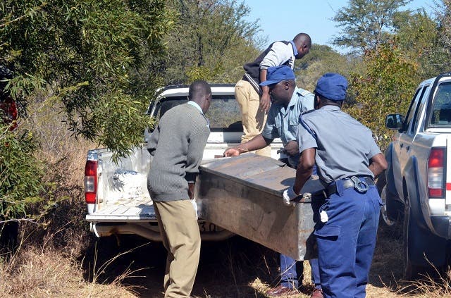 FILE picture of police loading a body into a metal coffin