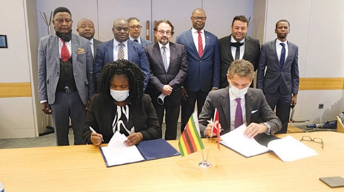 NRZ acting general manager Mrs Respina Zinyanduko and Yapı Merkezi chairman Basar Arıoglu sign the memorandum of understanding that is expected to see the transformation of the NRZ, while NRZ board chair Advocate Martin Dinha looks on, behind Mrs Zinyanduko in Istanbul, Turkey recently