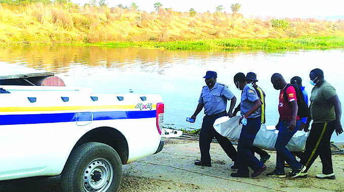 Search teams recover a body after a boat capsized in Lake Kariba yesterday