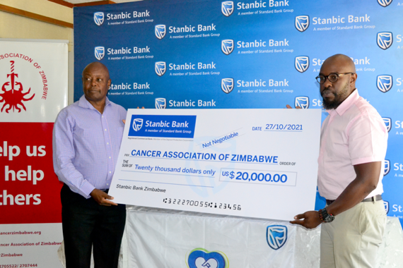 Stanbic Bank non-executive board member, Simbarashe Mhuriro (right) hands over the US$ 20 000.00 dummy cheque to CAZ Chairman, Eugene Mlambo (left) at the handover ceremony over the weekend