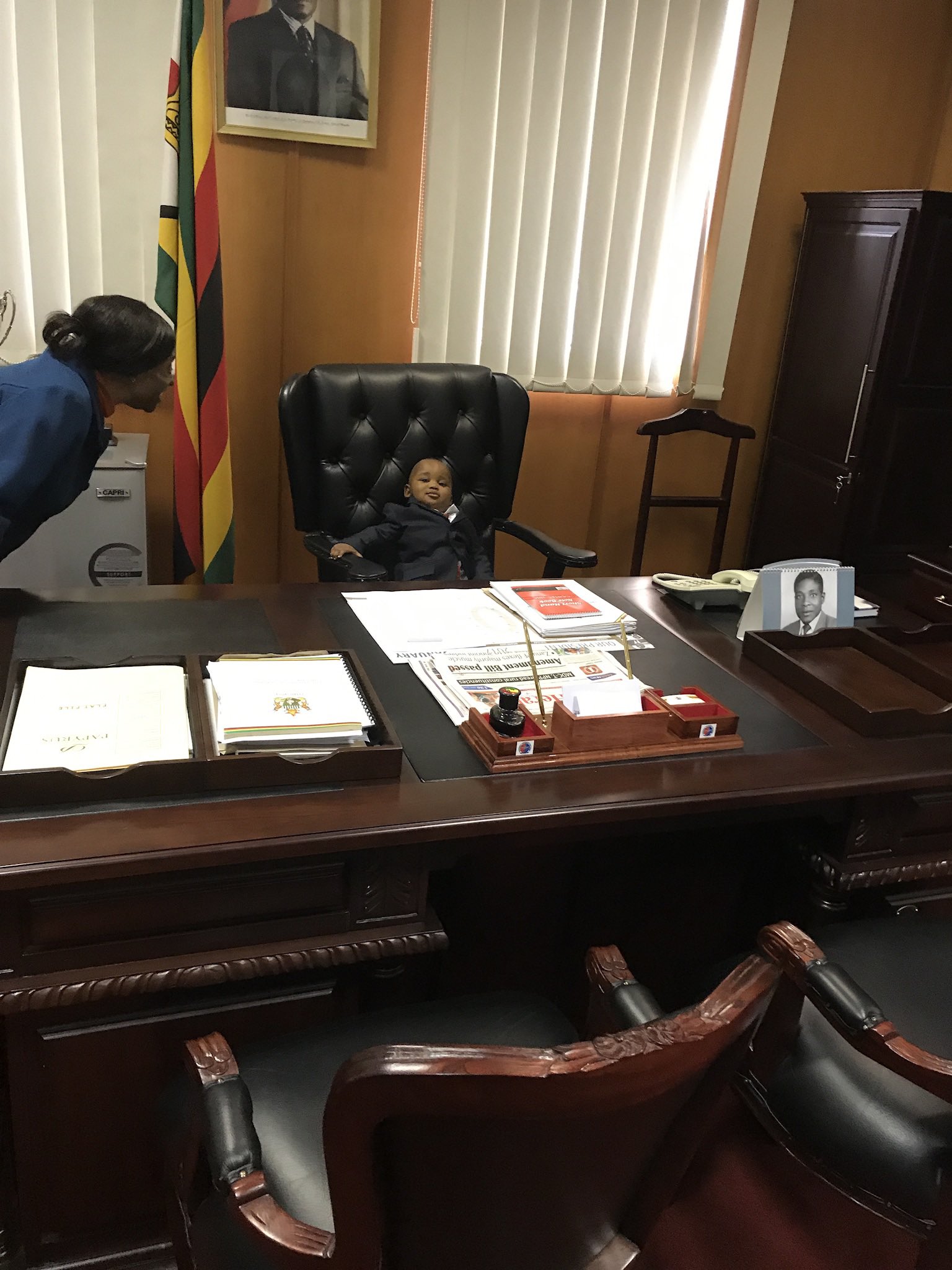 Susan Mutami's child seen here with President Emmerson Mnangagwa's personal assistant of more than 30 years, Magna Muganhiri (left). The picture was taken in 2017 in Mnangagwa's office when he was Vice President