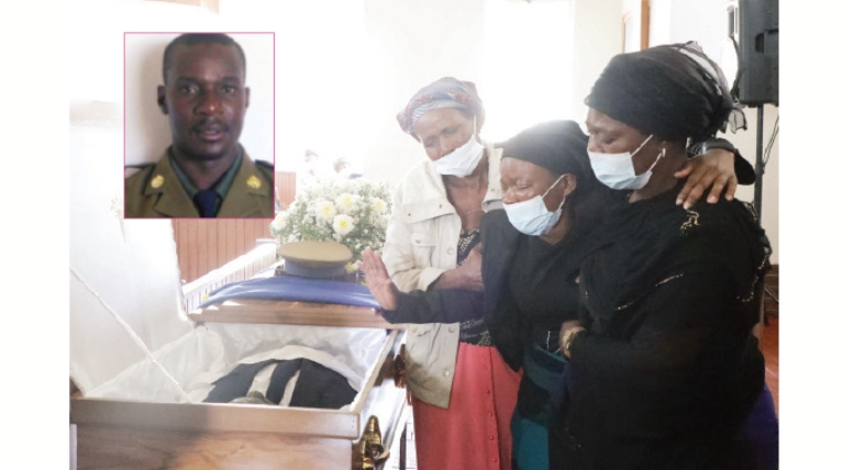 Relatives hold Nelia Hove, the widow of slain police Inspector Maxwell Hove (inset) during the body viewing at Mkushi Depot (Picture via The Herald)