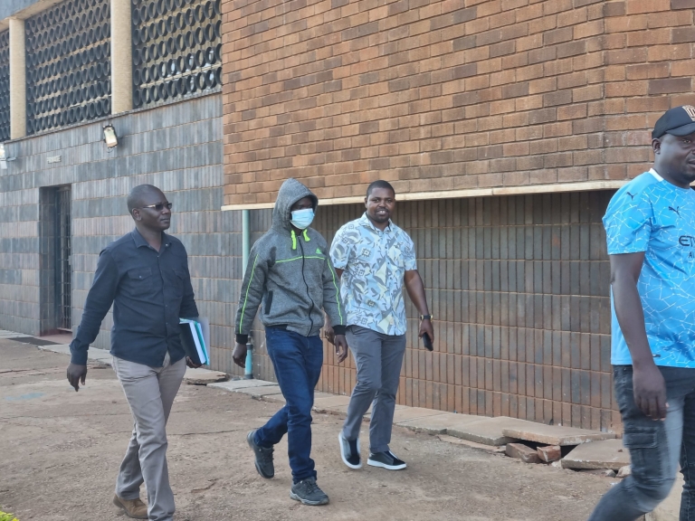 Zimbabwe Anti-corruption Commission (ZACC) officer Smart Marlon Mandofa with face mask appears at the Magistrates Court in Harare with his lawyer Admire Rubaya (right)