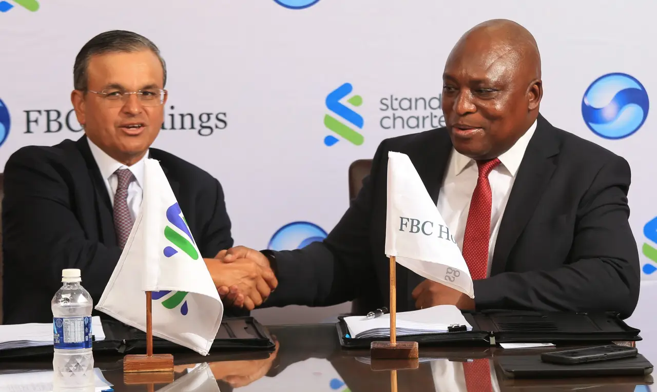 FHL group chairperson Herbert Nkala (right) seen in this picture as FBC Holdings Limited (FBCH) signs agreement to purchase Standard Chartered’s business in Zimbabwe.