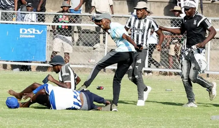 A Highlanders fan kicks a Dynamos supporter on the ground during the chaos that erupted at Barbourfields Stadium with Dynamos leading their bitter rival 2-0 just before halftime (Picture via The Chronicle)