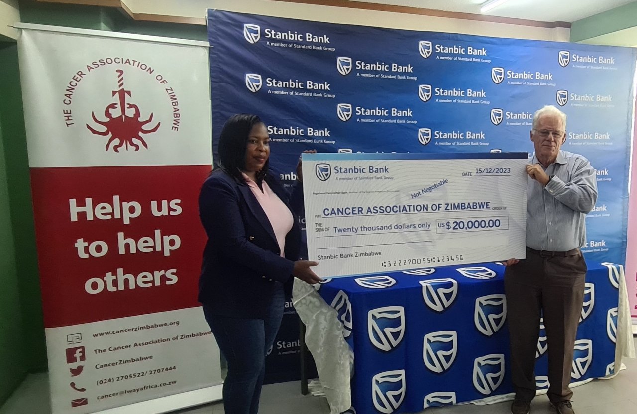 Stanbic Bank Manager, Brand and Advertising, Tariro Memo (left) hands over the dummy US$20 000 cheque for chemotherapy drugs to CAZ Board Treasurer, Don MacDonald.
