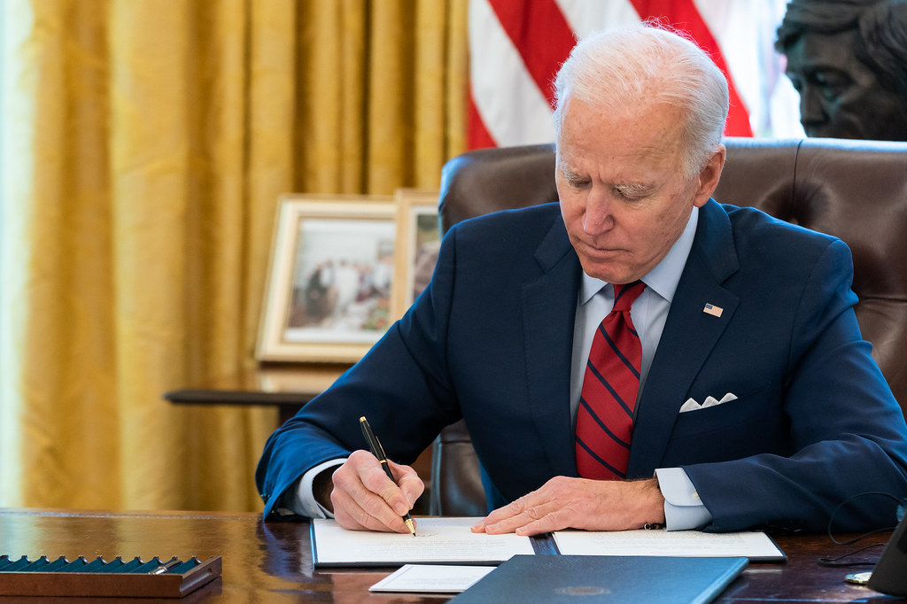 President Joe Biden signs two executive orders on healthcare Thursday, Jan. 28, 2021, in the Oval Office of the White House. (Official White House Photo by Adam Schultz)