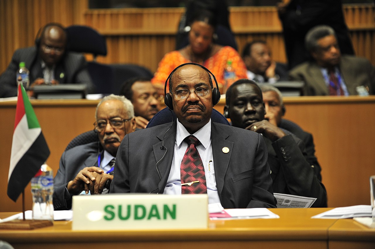 Omar Hassan Ahmad al-Bashir, then president of Sudan, listens to a speech during the opening of the 20th session of The New Partnership for Africa's Development in Addis Ababa, Ethiopia, Jan. 31, 2009. (Picture via U.S. Navy photo by Mass Communication Specialist 2nd Class Jesse B. Awalt/Released, Public domain, via Wikimedia Commons)