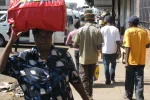 Zimbabwe ranked among world’s toughest places to call home amid deepening crisis Harare, Zimbabwe, 7 October 2015. A street scene showing a woman carrying her luggage on her head whilst walking along a street. — Photo by Maboss283 via DepositPhotos.com