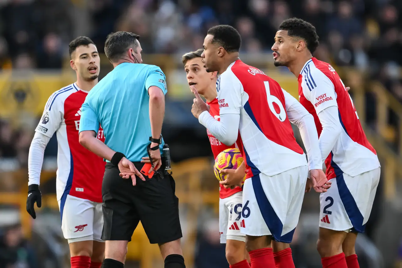 Arsenal players Gabriel Martinelli, Leandro Trossard, Gabriel Magalhães and William Saliba surround Referee Michael Oliver after he gives the red card to Myles Lewis-Skelly of Arsenal during the Premier League match Wolverhampton Wanderers vs Arsenal at Molineux, Wolverhampton, United Kingdom, 25th January 2025 — Photo by NewsImages via DepositPhotos.com